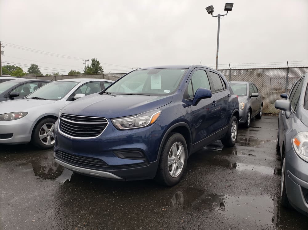 Before: an ordinary phone photo of a blue SUV on a wet used-car lot