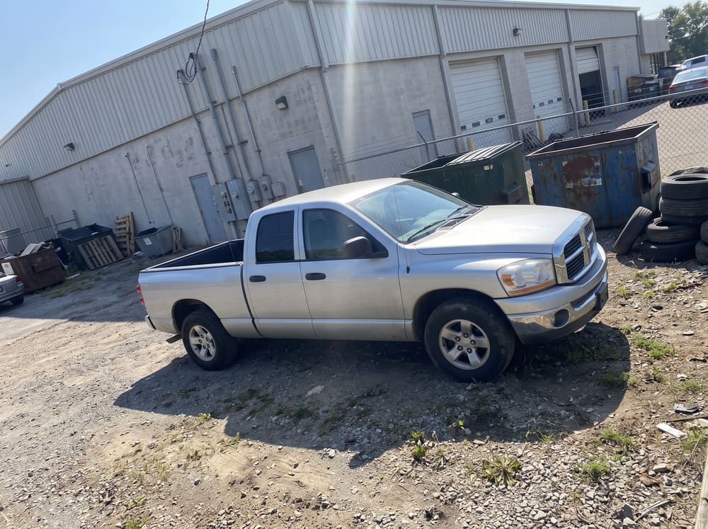 Before: a silver pickup truck photographed behind a service building in harsh sun
